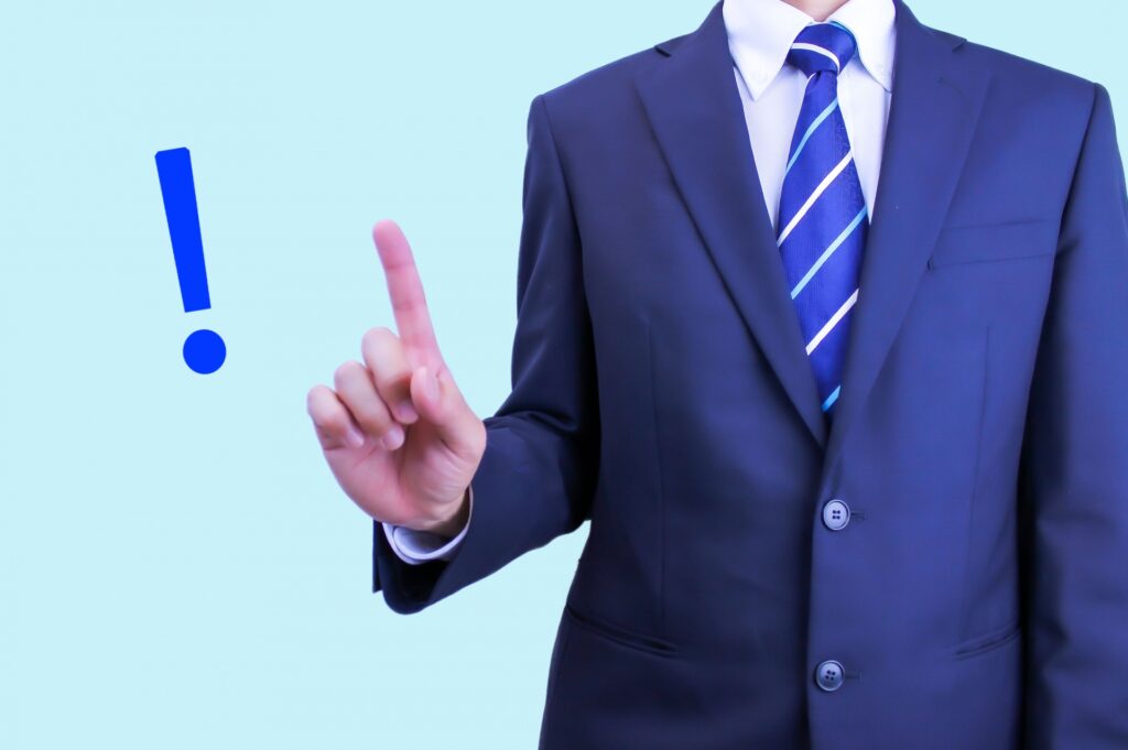 指を立ててポイントを示すスーツの男性