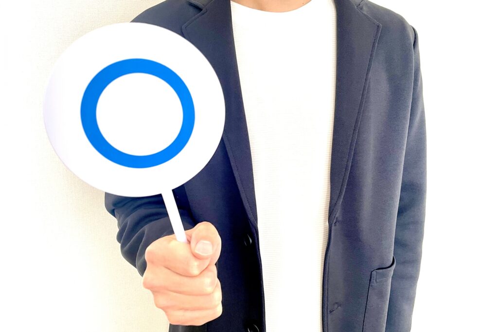 「良い」を示すカードを持った男性