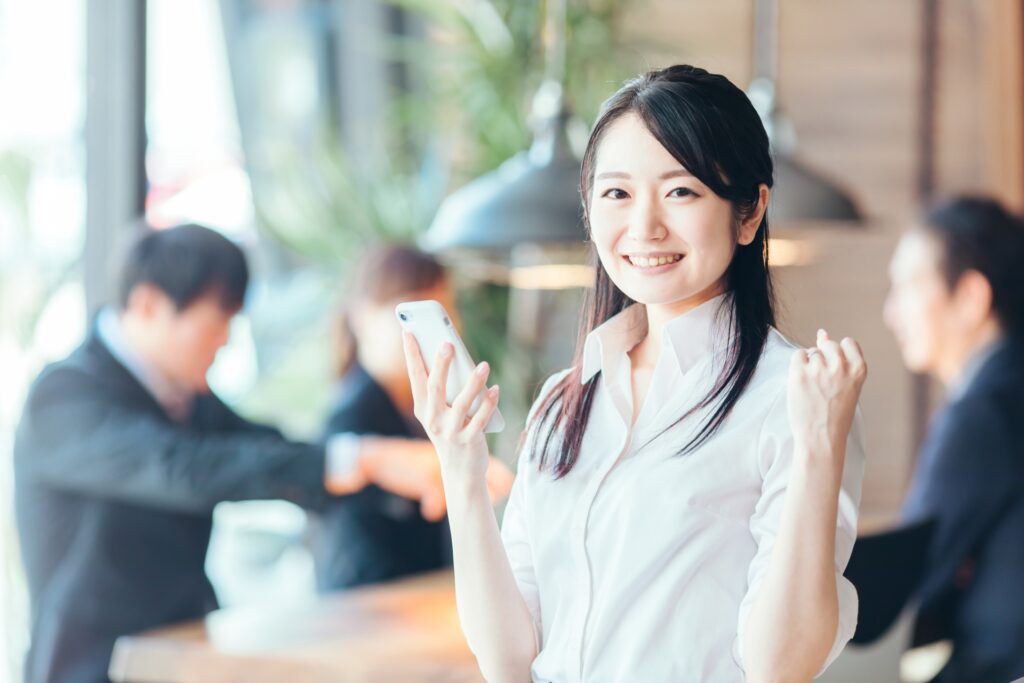 スマホを片手に持つ笑顔の女性