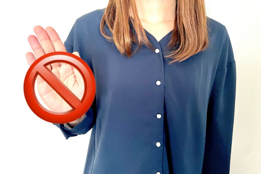 手で禁止マークを持つ女性