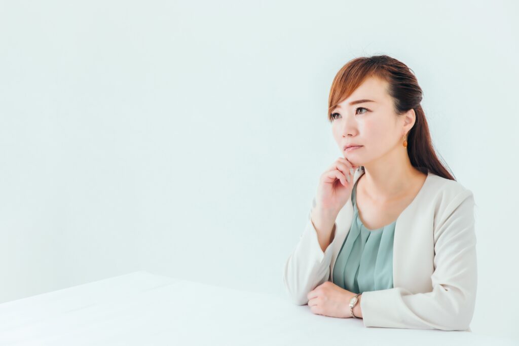 顎に手を当てて困っている女性