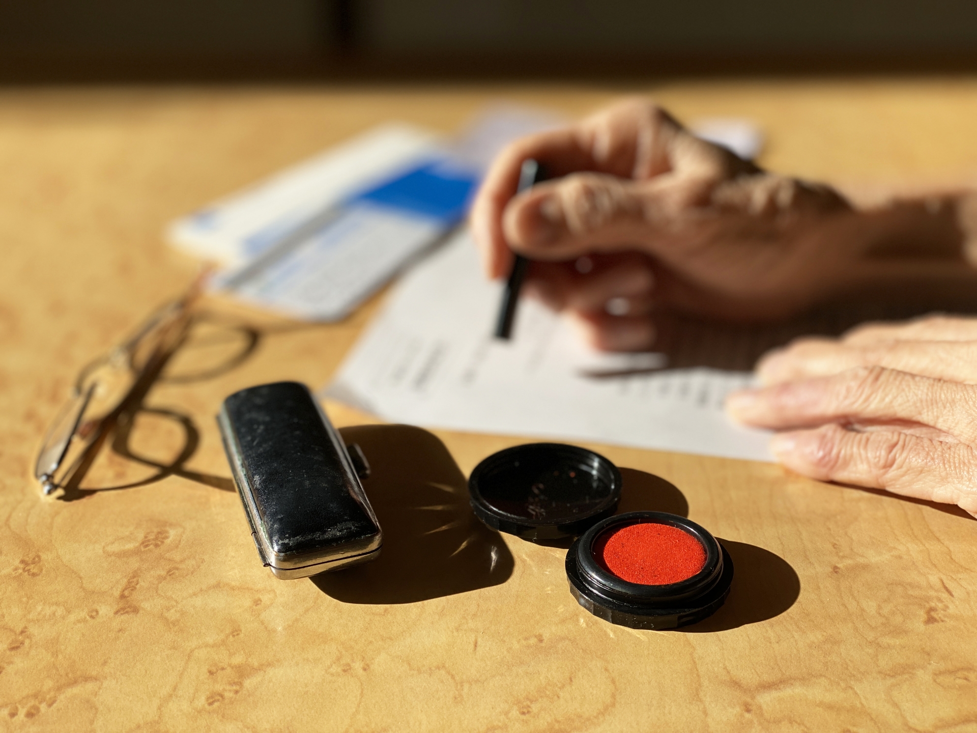 用紙にハンコを押す高齢者の手