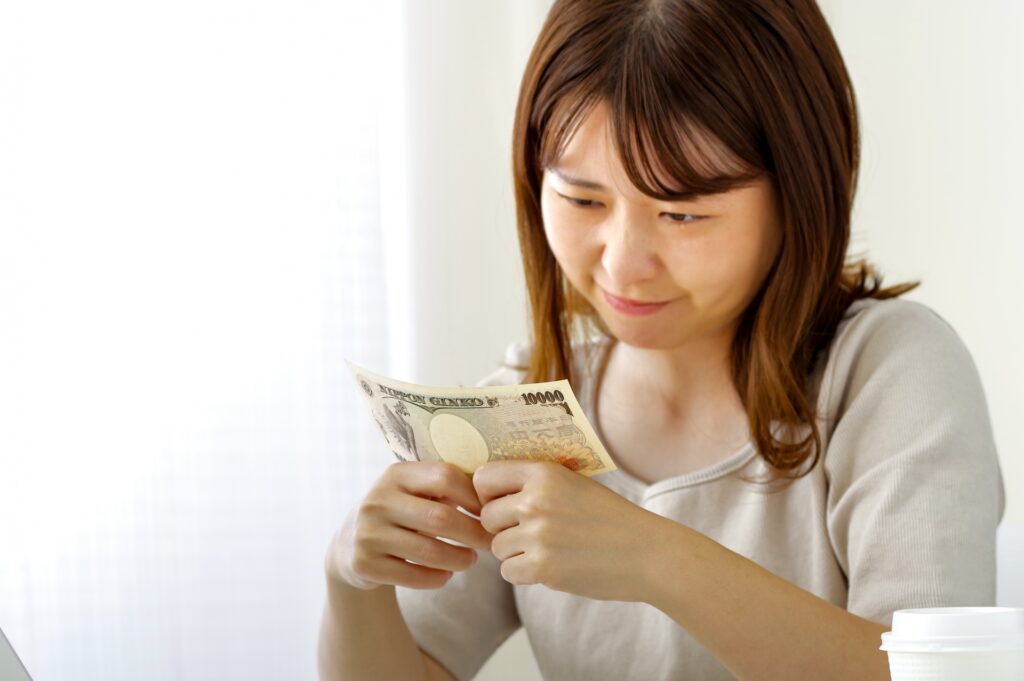 お金を見つめる若い女性